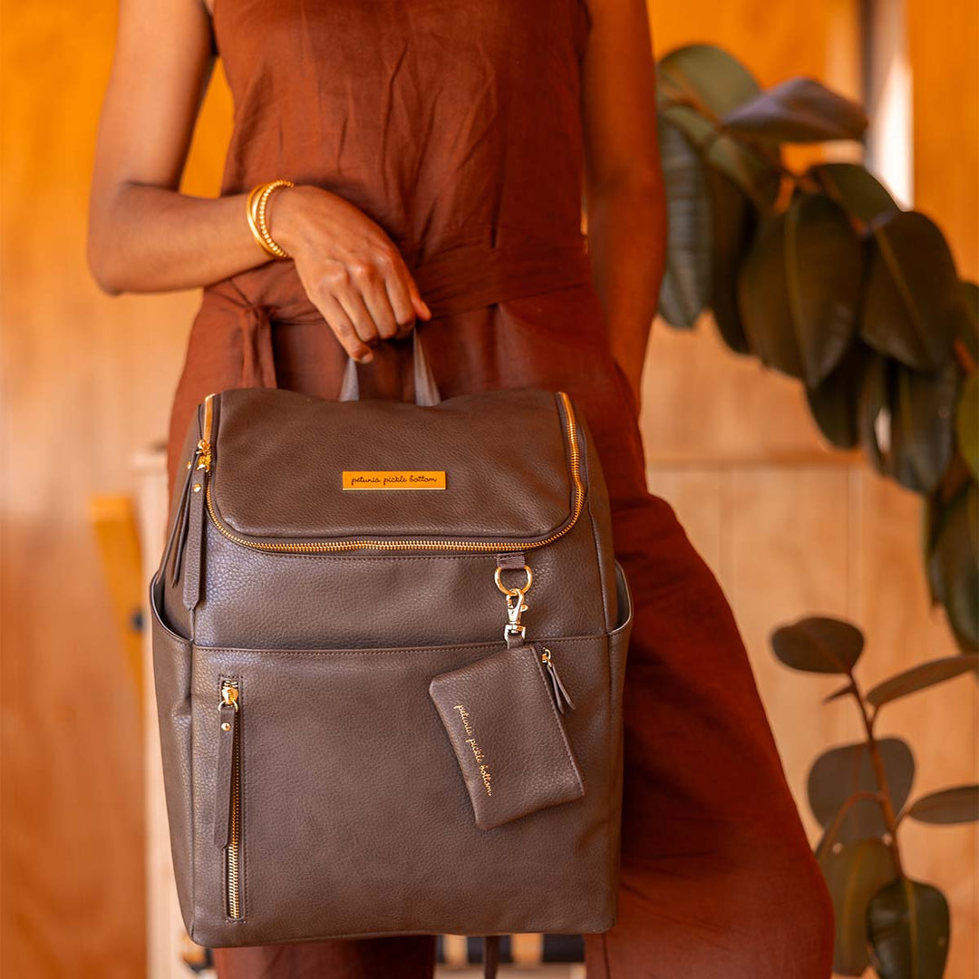 mom holding the Tempo Diaper Bag Backpack in Saddle