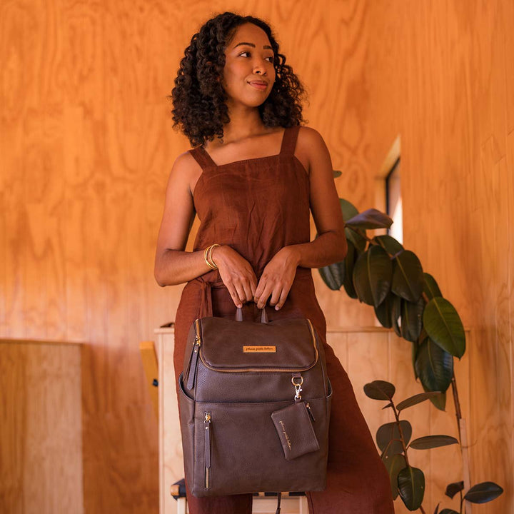 mom holding the Tempo Backpack in Saddle