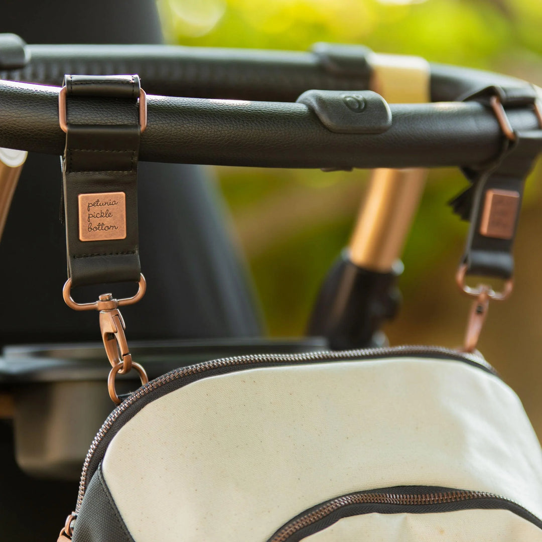 pivot pack in sand black attached to the stroller by the valet stroller clips in antique copper